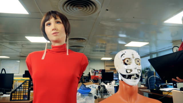Roboter-Kopf-und-weibliche-Schaufensterpuppe-bewegen-sich-ihre-Münder-unter-Experten-Kontrolle