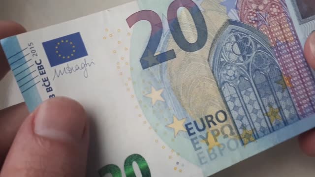 20-Euro-Banknote-in-den-Händen-eines-Typen