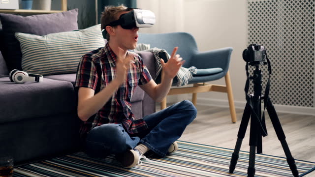 Junge-Mann-Blogger-ist-Aufzeichnung-von-Video-über-Virtual-Reality-Brillen-auf-dem-Boden-zu-Hause-sitzen