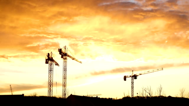 Construction-cranes-silhouettes-at-the-time-of-red-cloudy-sunset