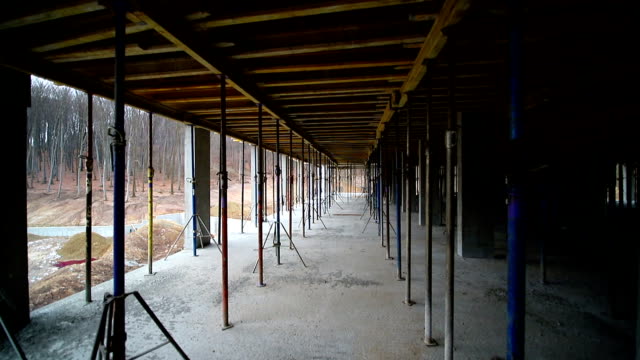 Movement-of-the-camera-between-the-building-supports-that-support-concrete-structures.-Unfinished-floor-on-the-construction-site