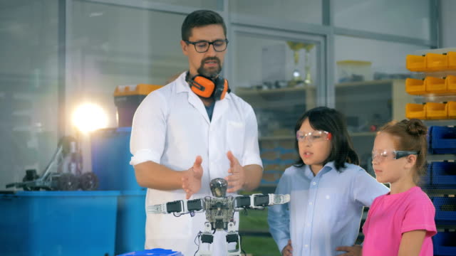 Schulwissenschaftslehrerin-zeigt-intelligente-Schulkinder-Robotik-Technik