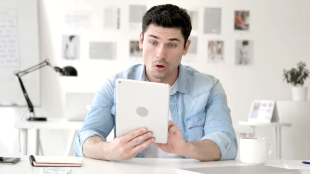 Casual-Young-Man-in-Shock-while-Using-Tablet