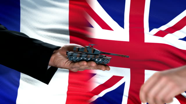 France-and-Great-Britain-officials-exchanging-tank-for-money,-flag-background