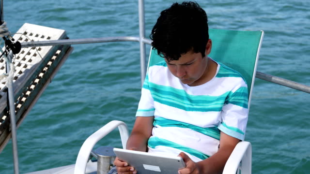 Jovencito-usando-la-tableta-digital-en-el-yate