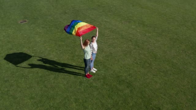 Aerial-view-of-lgbt-couple-holding-rainbow-flag