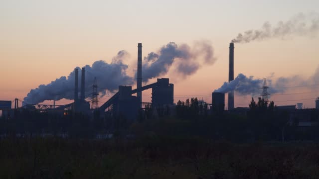 Smoke-from-the-tubes-of-a-metallurgical-plant-against-the-sky-at-sunrise