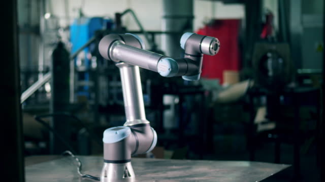 Moderner-Roboter-arbeitet-in-einer-Fabrik-und-bewegt-sich-auf-einem-Tisch.