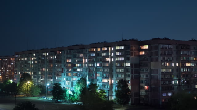 Mehrstöckiges-Gebäude-mit-wechselnder-Fensterbeleuchtung-bei-Nacht.-Zeitraffer