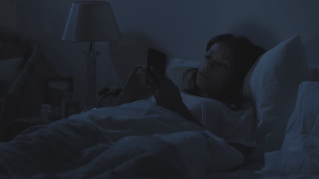 Frau-mit-Telefon-im-Bett-in-der-Nacht