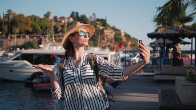 Millennial-Hipster-Frau-Tourist-in-lässigen-Outfit-mit-Rucksack-machen-Selfie-in-Yachtpier,-Marina