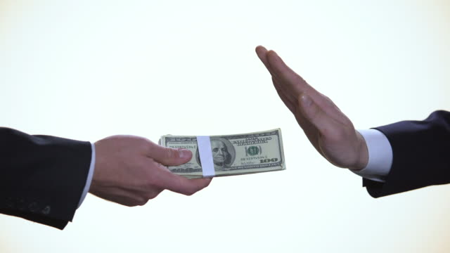 Faceless.-White-background.Close-up.-Businessman-refusing-bribe-in-dollars