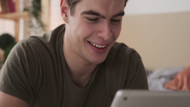 Hombre-alegre-usando-tableta-digital-en-casa