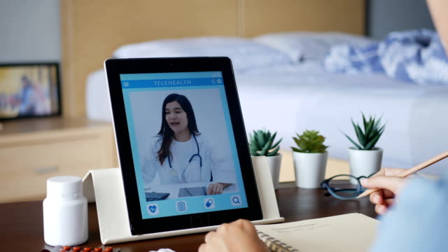 4K.-mujer-enferma-usar-videoconferencia,-hacer-consulta-en-línea-con-el-médico-a-través-de-la-tableta,-paciente-preguntar-al-médico-sobre-la-enfermedad-y-la-medicación-a-través-de-videollamada.-Telesalud,-Telemedicina-y-hospital-online