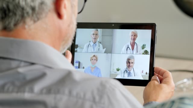 Arzt-arbeitet-von-zu-Hause-aus-und-unterhält-sich-mit-seinem-Teamwork-in-einer-Videokonferenz