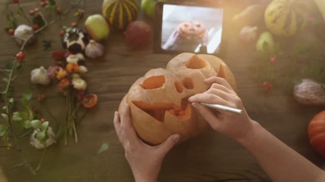 Mujer-talla-la-decoración-de-Halloween-usando-un-manual-de-tableta