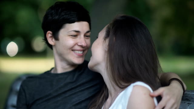 Close-up:-two-lesbians-kisses-on-bench-in-park