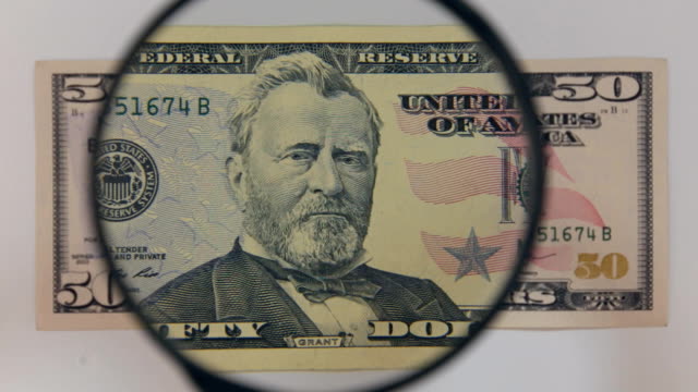 Approaching-using-a-magnifying-glass-fifty-dollar-bill