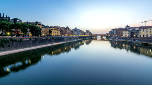 River-Arno-and-famous-bridge-Ponte-Vecchio-day-to-night-timelapse-after-sunset-from-Ponte-alle-Grazie-in-Florence,-Tuscany,-Italy