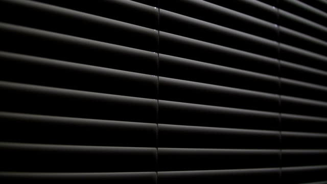 Light-from-the-window-penetrates-into-the-dark-room-through-the-blinds.-Close-up