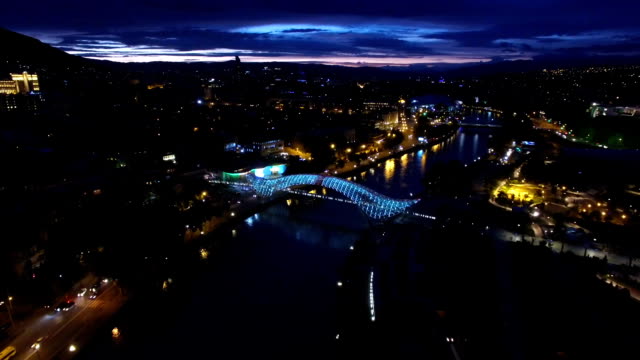 Puente-de-la-paz-en-Tbilisi,-capturados-desde-vista-de-pájaro,-brillo-del-rayo-LED