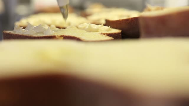 pastry-chef--hands-stuffed-Easter-sweet-bread-cakes-with-custard,-closeup-on-the-worktop-in-confectionery