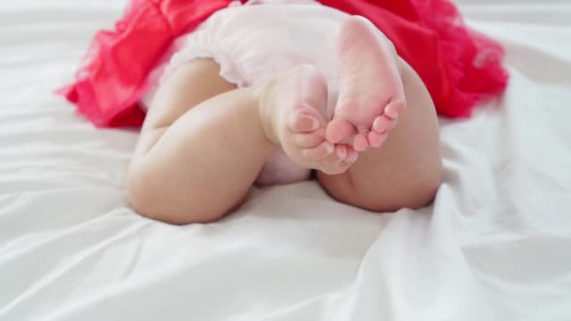 Baby-Mädchen-auf-dem-Bauch-liegend-und-schwingen-ihre-Beine-um-zu-versuchen,-in-Zeitlupe-erschossen-kriechen