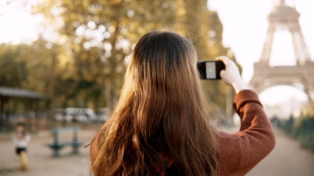 Rückansicht-der-jungen-Frau,-die-das-Fotografieren-auf-Smartphone.-Teenager-touristische-Erkundung-des-Eiffelturms-in-Paris,-Frankreich
