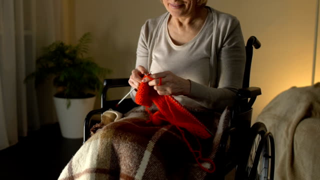 Behinderte-Frau-stricken-in-Raum-und-lächelnd,-finanziell-abgesichert-Alter,-hobby