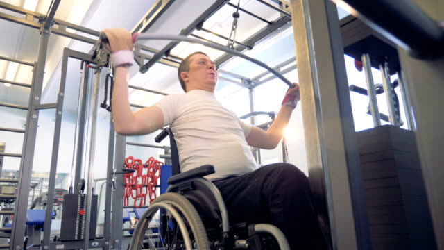 Behinderte-Mensch-macht-die-Übungen-in-einem-Fitnessstudio-Training-Apparat.