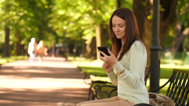 Brunette-woman-texting-in-smartphone