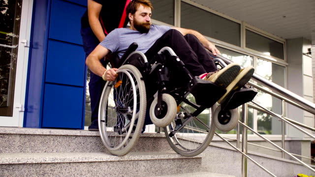 Hombre-ayudando-a-bajar-a-un-hombre-discapacitado