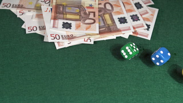 Dice-rolling-against-Green-background-with-50-euros-Bills,-slow-motion