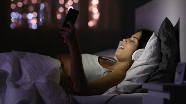 Teen-singing-and-listening-to-music-with-a-phone-in-the-night