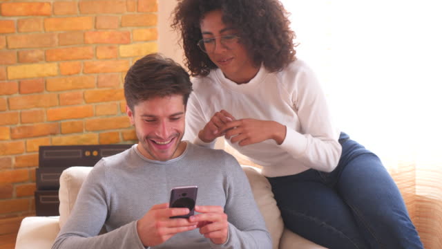 Couple-using-mobile-phone-and-disagree-together-at-home