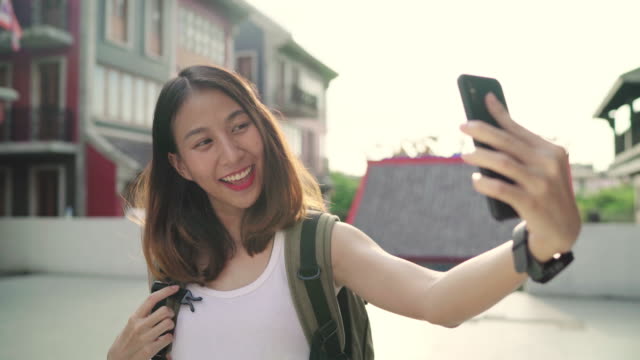 Fröhlich-schönen-jungen-asiatischen-Backpacker-Blogger-Frau-mit-Smartphone-unter-Selfie-unterwegs-in-Chinatown-in-Peking,-China.-Lebensstil-Rucksack-Tourist-Reisen-Urlaub-Konzept.