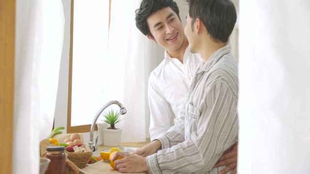 Happy-gay-couple-cooking-together-in-home-kitchen.-People-with-gay,-homosexual,-relationship-concept.