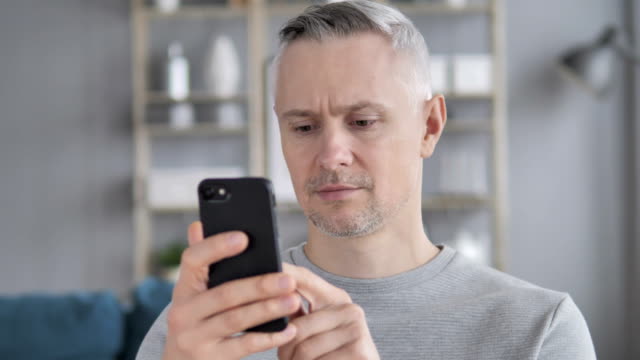 Retrato-de-hombre-de-pelo-gris-ocupado-con-Smartphone