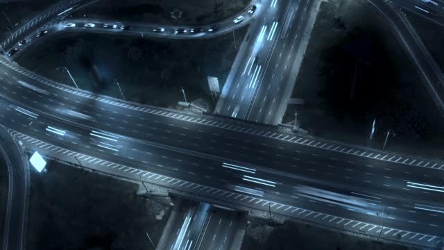 Tráfico-en-el-intercambio-de-la-autopista.-Noche-aérea-vista-timelapse-tráfico-de-la-ciudad.