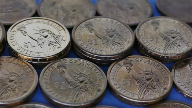 Amerikanische-Ein-Dollar-Münzen-auf-blauem-Papier-Hintergrund