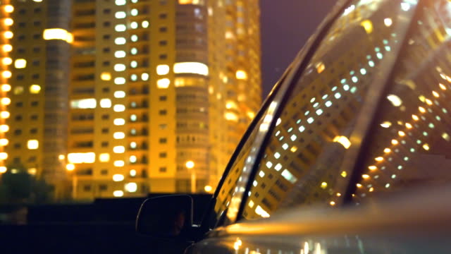 The-car-rides-on-a-background-of-buildings.-evening-night-time