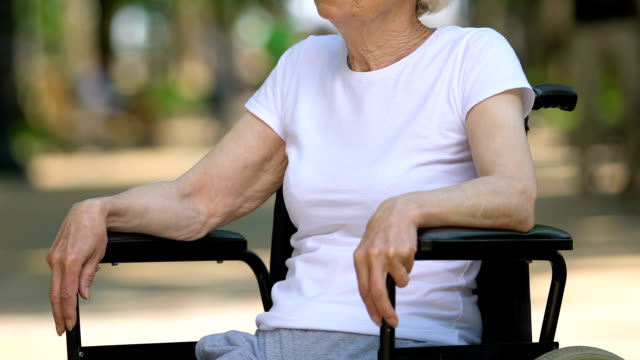 Cheerful-disabled-woman-sitting-in-park-and-breathing-fresh-air,-rehabilitation