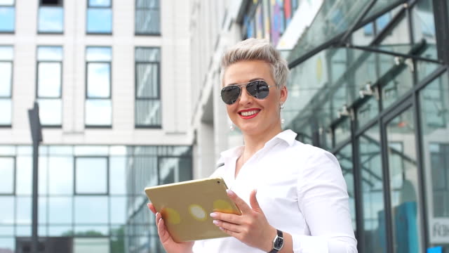Erwachsene-Geschäftsfrau-mit-Tablet-PC-mit-Bürobezirk-auf-Hintergrund