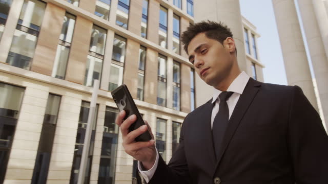 Attractive-Businessman-Using-Telephone-in-Downtown