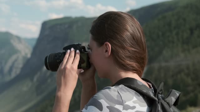 Weibliche-Reisende-macht-schöne-Bilder-mit-der-Kamera,-während-sie-auf-dem-Gipfel-des-Berges-steht.-Nahaufnahme