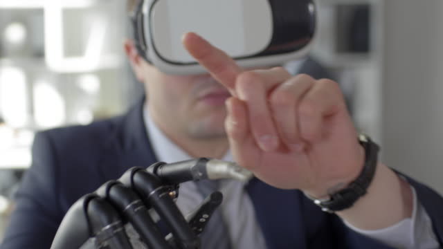 Hombre-de-negocios-con-mano-biónica-usando-gafas-de-realidad-virtual-en-la-oficina