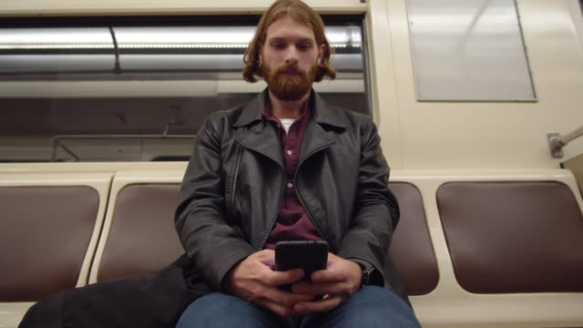 Man-Sitting-in-Subway-Car