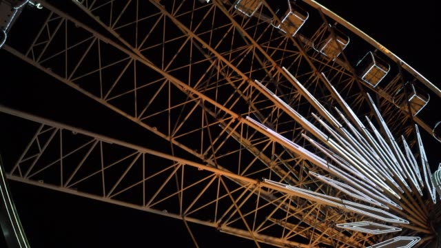 Ferris-wheel.-A-ferris-wheel-rotates-against-the-background-of-the-night-sky.-Close-up-of-a-Ferris-wheel-with-night-illumination.-lluminated-Ferris-Wheel-construction-rotating-against-dark-night-sky-background.