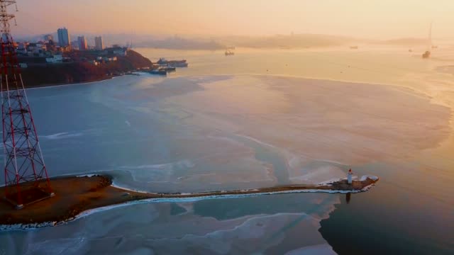 Aerial-winter-view-of-the-Tokarevskiy-lighthouse---one-of-the-oldest-lighthouses-in-the-Far-East,-still-an-important-navigational-structure-and-popular-attractions-of-Vladivostok-city,-Russia.