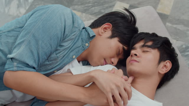 Junge-asiatische-homosexuell-Paar-schlafen-zusammen-zu-Hause.-Teen-korean-LGBTQ-Männer-glücklich-entspannen-Ruhe-liegen-auf-dem-Bett-im-Schlafzimmer-im-Haus-am-Morgen.